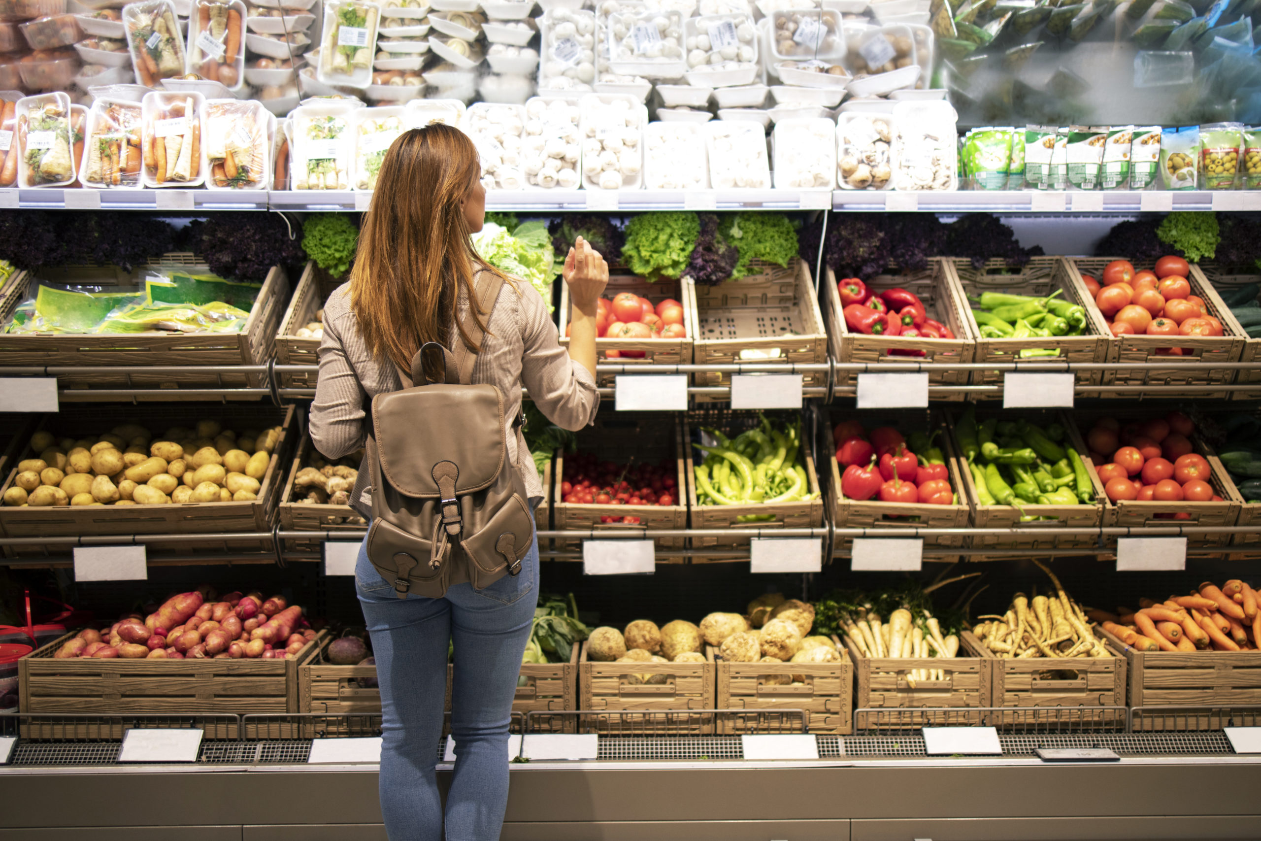 good-looking-woman-standing-in-front-of-vegetable-shelves-choosing-what-to-buy-scaled.jpg